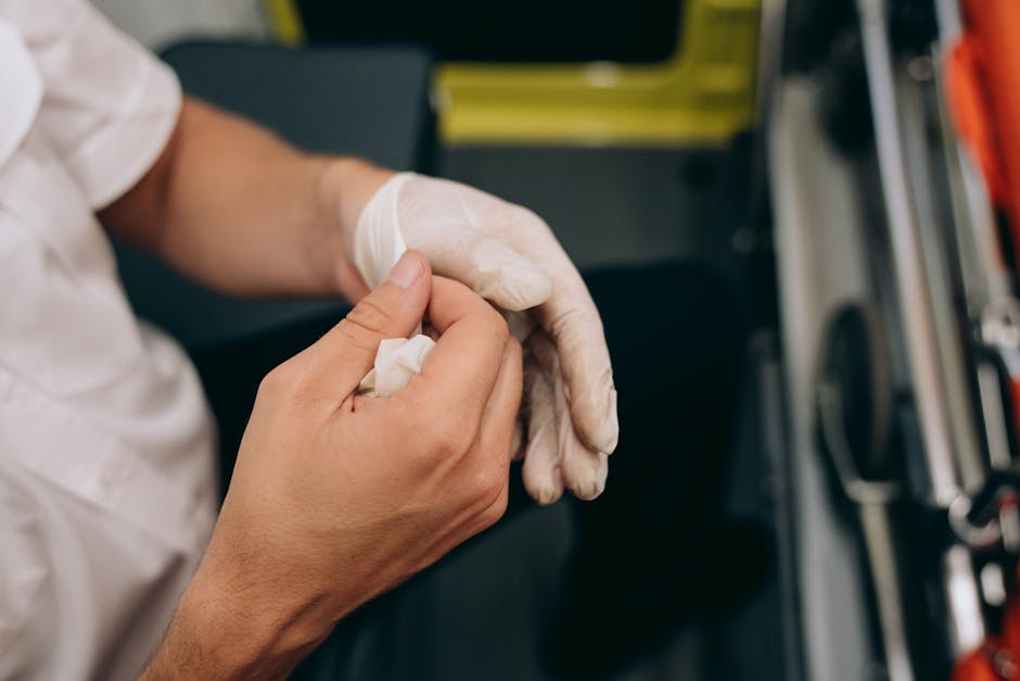 Close-up view of a person wearing a white shirt and white gloves applying a small amount of antiseptic or cleaning solution to their hands, with a background featuring a moving van or vehicle associated with house removals. The scene suggests preparation for a home relocation or furniture transport process, with the focus on hygiene and safety measures during packing or loading activities. The vehicle's interior or exterior may contain packing materials, boxes, or moving equipment, though these are not explicitly visible. This image emphasizes the careful handling and attention to cleanliness practiced by Merton Movers during same-day removals in Wimbledon, supporting efficient and professional packing and moving services.